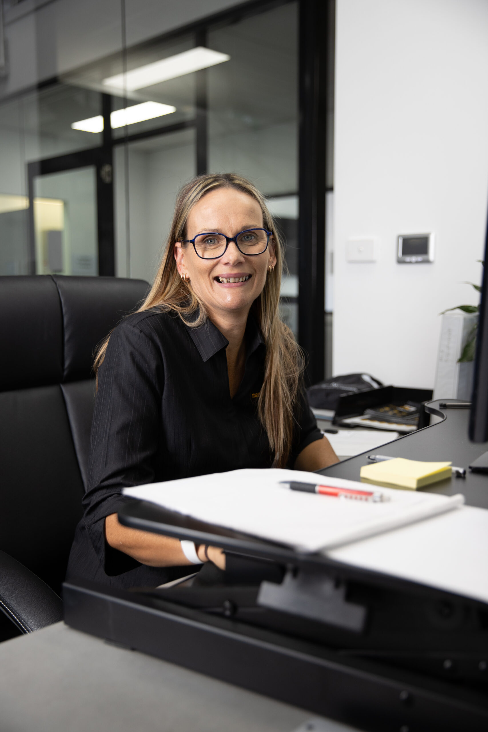woman smiling at camera sat at desk