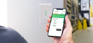 person using phone with access control app outside warehouse