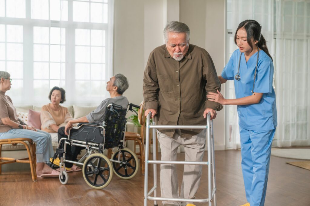 nurse helping elderly man using a walker