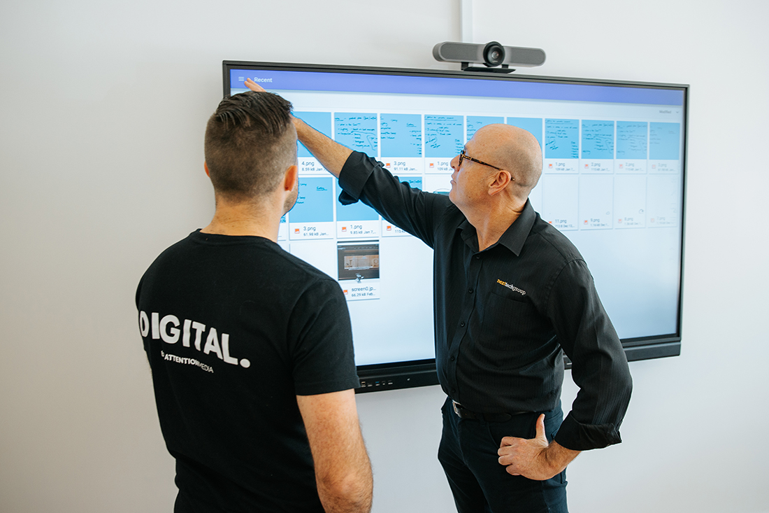 2 men collaborating in front of an interactive screen