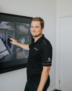 man in front of interactive screen showing security software smiling at camera