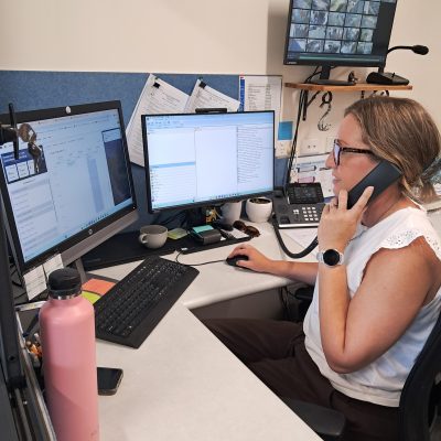lady on the phone at her desk with monitors