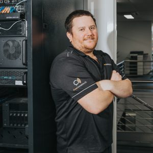 man in next tech group uniform in front of a server