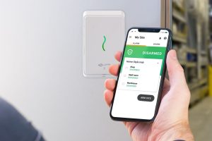 person using phone with access control app outside warehouse