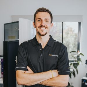 man smiling at camera with arms crossed