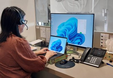 lady at a desk using phone headset and desk phone with 3cx