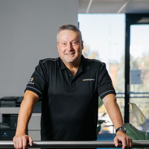 man in next tech group uniform smiling at camera